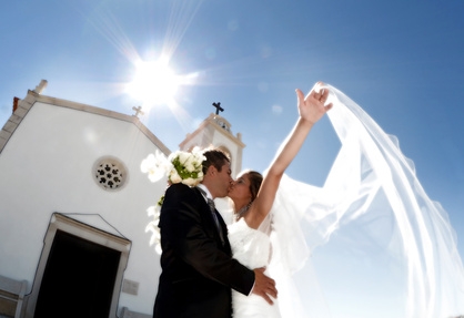 Bride and groom kissing in front of church