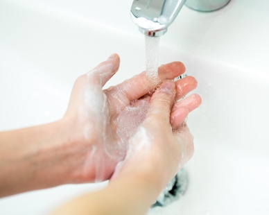 Washing of hands with soap in bathroom close up