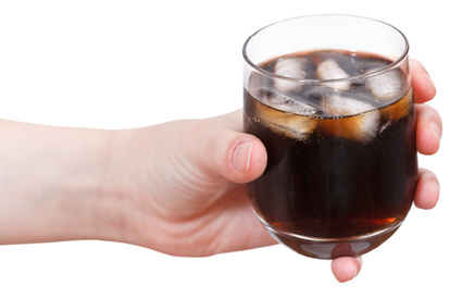 hand holds cola with ice in glass isolated