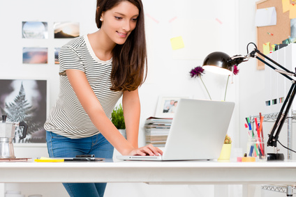 Portrait of young woman working with laptop in her workspace