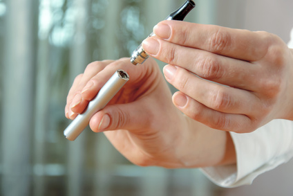 Female hand detaches part of the electronic cigarette: battery and clearomizers. Concept: safe way of smoking, how to stop smoking