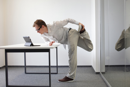 leg exercise durrng office work - standing man reading at tablet in his office